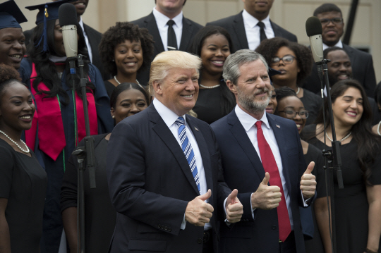 13일(현지시간) 도널드 트럼프(앞줄 왼쪽) 미국 대통령과 제리 팔월(오른쪽) 리버티대학 총장이 학위 수여식에서 양쪽 엄지를 치켜올리고 있다. /버지니아=UPI연합뉴스
