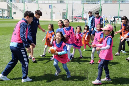현대글로비스 럭비단 선수들이 13일 인천지역 다문화가정 어린이들과 함께한 일일 럭비 교실 행사에서 어린이들과 미니 럭비 게임을 하고 있다./사진제공=현대글로비스