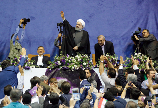 오는 19일(현지시간) 대선에서 연임에 도전하는 하산 로하니 이란 대통령이 13일 테헤란의 선거 유세장에 도착해 지지자들에게 손을 흔들고 있다. 로하니 대통령은 현재 지지율 40% 안팎으로 후보 5명 가운데 1위를 지키고 있지만 득표율이 과반을 넘지 못하면 2위가 유력한 보수파 라이시와 모하마드 바게르 갈리바프 테헤란 시장과 결선투표에서 최종 승부를 가리게 된다.    /테헤란=EPA연합뉴스
