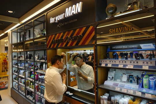 서울 올리브영 명동본점에 마련된 ‘그루밍존’에서 남성 고객이 제품을 사용해보고 있다. /사진제공=올리브영