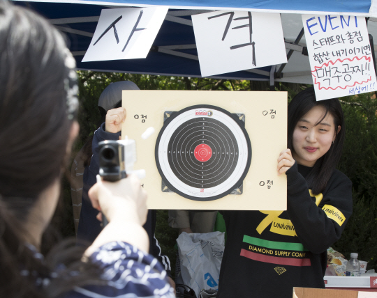 16일 서울 서대문구 이화여대에서 열린 축제에서 학생들이 ‘맥주 공짜’ 경품을 내건 사격게임 부스에서 장난감 총으로 과녁을 향해 사격하고 있다. /연합뉴스