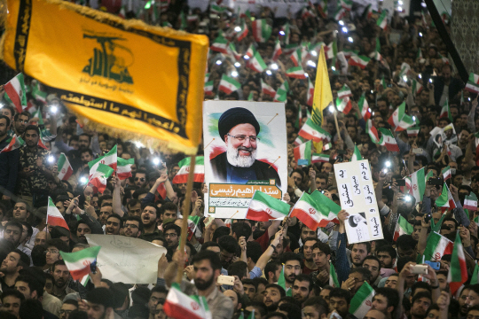 이란 대선이 막판으로 치닫고 있는 가운데 하산 로하니(위쪽 사진) 대통령과 에브라힘 라이시 후보를 지지하는 시민들이 각 후보의 사진 및 국기를 흔들며 환호하고 있다. /마슈하드·테헤란=AFP·신화연합뉴스