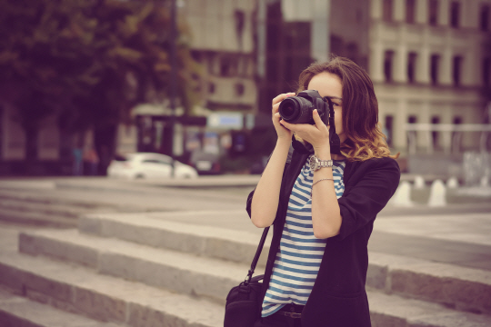 한 여성이 디지털카메라를 들고 사진을 촬영하고 있다. 사진 다운로드수에 따라 작가의 수익이 늘어나는 스톡 사진 사이트가 보편화되면서 자신이 찍은 사진을 직접 올리는 일반인 작가도 늘고 있다. /사진제공=셔터스톡