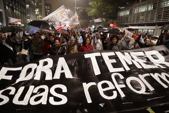 18일(현지시간) 브라질 상파울루에서 시민들이 뇌물 사건 연루 의혹을 받고 있는 미셰우 테메르 대통령에 대해 “물러나라” “개혁 중단하라” 등의 구호를 외치며 시위하고 있다. /상파울루=AP연합뉴스