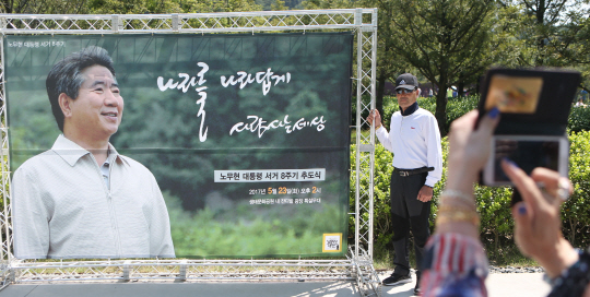 노무현 전 대통령 서거 8주기 추도식을 하루 앞둔 22일 경남 김해시 진영읍 봉하마을에서 한 방문객이 기념사진을 찍고 있다. 노무현재단은 추도식이 열리는 23일 봉하마을 방문객이 예년의 두 배인 3만명 이상일 것으로 예상했다.  /김해=연합뉴스