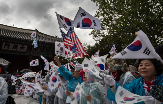 지난 13일 서울 중구 대한문 앞에서 마지막으로 열린 ‘탄핵무효 국민저항 총궐기 국민대회’에서 참가자들이 ‘탄핵무효’와‘박근혜 대통령 석방’을 외치며 태극기를 흔들고 있다. /연합뉴스