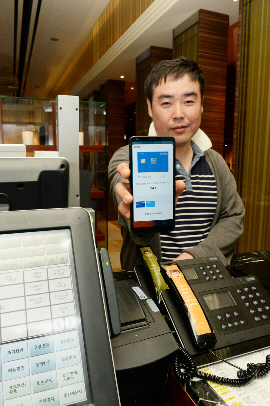 LG전자 직원이 레스토랑에서 신용카드 대신 LG페이가 작동 중인 LG G6로 결제를 요청하고 있다./사진제공=LG전자