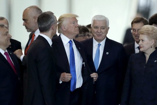 25일(현지시간) 도널드 트럼프(앞줄 가운데) 미국 대통령이 벨기에 브뤼셀에서 열린 북대서양조약기구(NATO·나토) 정상회의에 참석한 자리에서 몬테네그로의 두스코 마르코비치(앞줄 오른쪽 두번째) 총리를 오른쪽 팔로 제지한 후 아무렇지 않다는 듯 옷매무새를 가다듬고 있다. /브뤼셀=AP연합뉴스