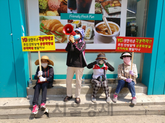 삼성강변아파트 주민들이 19일 YG사옥 앞에서 피켓시위를 하고 있다./신다은 기자