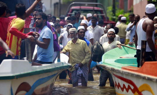 14년만의 최악의 폭우 피해를 겪고 있는 스리랑카의 칼루타라 지구에서 주민들이 27일 홍수를 피하기 위해 보트를 기다리고 있다.  /칼루타라=AP연합뉴스