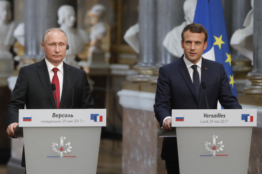 29일(현지시간) 에마뉘엘 마크롱(오른쪽) 프랑스 대통령과 블라디미르 푸틴(왼쪽) 러시아 대통령이 파리 베르사유 궁에서 정상회담을 한 뒤 기자회견을 하고 있다. /파리=타스연합뉴스