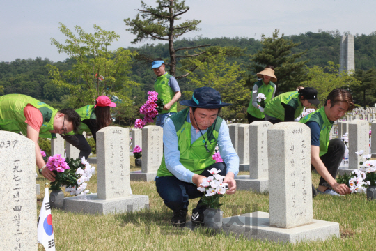 코오롱 임직원들이 31일 국립 서울현충원을 찾아 묘역정화활동을 펼치고 있다./사진제공=코오롱
