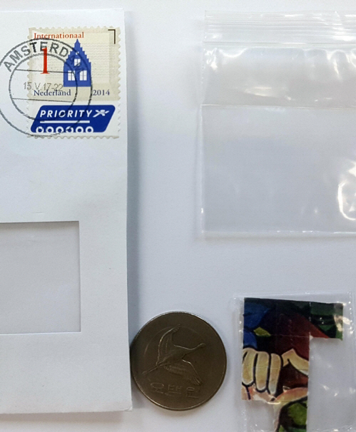 검찰에 적발된 LSD 스티커 마약(동전 오른쪽)