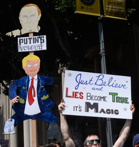 3일(현지시간) 미국 로스앤젤레스 퍼싱 스퀘어에서 ‘진실을 위한 행진’ 시위대가 ‘트럼프는 푸틴의 꼭두각시’라고 조롱하며 트럼프의 ‘러시아 커넥션’에 대한 철저한 조사와 납세 내역 공개를 요구하는 시위를 벌이고 있다./UPI연합뉴스