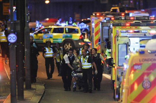 영국 런던 시내 런던 브리지와 인근 버러 마켓에서 3일(현지시간) 차량·흉기 테러가 발생한 가운데 경찰과 구급대원들이 부상자를 이송하고 있다.       /런던=AFP연합뉴스