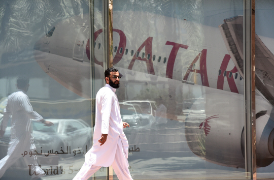5일(현지시간) 사우디아라비아의 수도 리야드에서 한 남자가 카타르항공 리야드 지점을 지나가고 있다. /리야드=AFP연합뉴스