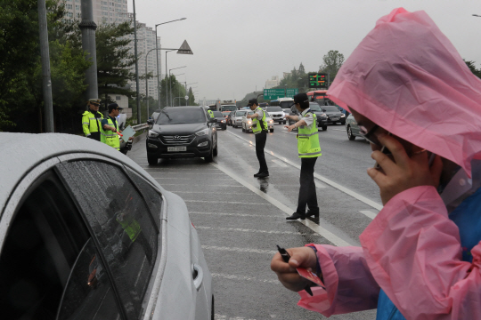 ‘전국 상습 체납차량 번호판 일제 영치의 날’인 7일 서울 서초구 경부고속도로 반포IC에서 서초구청 직원들과 경찰이 합동 단속을 하고 있다. 행정자치부는 이날 전국의 지방자치단체·경찰청과 함께 세 번 이상 자동차세나 과태료를 체납한 차량과 대포차의 번호판을 뜯어내 압수했다. /연합뉴스