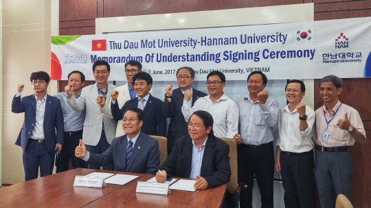 이덕훈(사진 앞줄 왼쪽) 한남대 총장이 베트남 빈증성 도립대학인 ‘투저우못 대학’과 상호협력 협약을 체결하고 있다. 양측관계자들과 화이팅을 외치고 있다. 사진제공=한남대