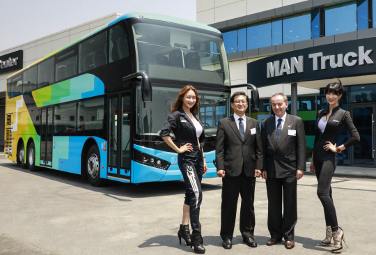 막스 버거(오른쪽 두번째) 만트럭버스코리아 사장과 이호형 버스상품영업담당 이사가 9일 경기도 평택 PDI센터에서 모델들과 함께 만 라이온스 2층버스를 공개하고 있다. /사진제공=만트럭버스코리아