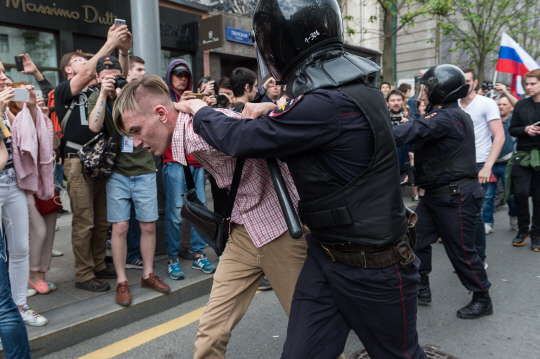 러시아 수도 모스크바에서 12일(현지시간) 반 정부 시위에 참여한 한 시민이 경찰에 목덜미가 잡힌 채 끌려가고 있다. /모스크바=신화연합뉴스
