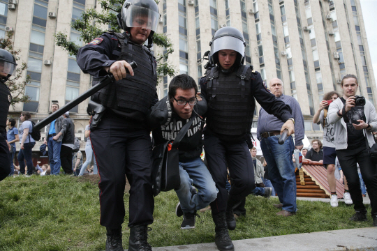 러시아 수도 모스크바에서 12일(현지시간) 반정부 시위에 참가한 한 시민이 경찰 두 명에게 잡혀 끌려가고 있다./모스크바=AFP연합뉴스