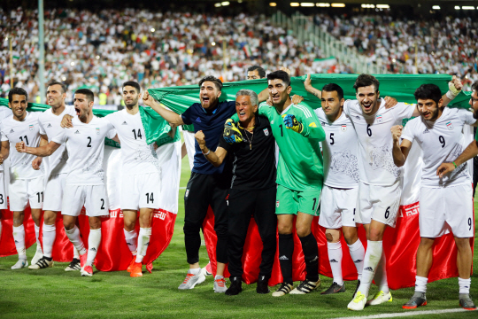 이란 축구 대표팀이 13일 우즈베키스탄전 승리로 2018 러시아 월드컵 본선 직행을 확정한 뒤 대형 국기를 두르고 환호하고 있다.  /테헤란=EPA연합뉴스