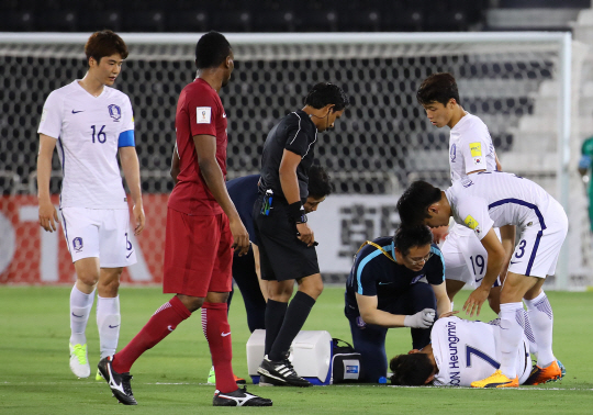 축구 대표팀 손흥민(7번)이 14일 카타르전에서 부상을 입어 응급처치를 받고 있다. /연합뉴스