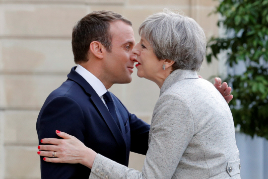 에마뉘엘 마크롱(왼쪽) 프랑스 대통령이 13일(현지시간) 파리 엘리제궁을 방문한 테리사 메이 영국 총리를 다정하게 맞이하고 있다. 두 정상은 이날 저녁 식사를 함께하며 브렉시트(영국의 유럽연합 탈퇴, Brexit) 협상에 관해 논의한 것으로 전해졌다.   /파리=로이터연합뉴스