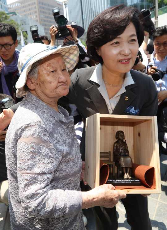 추미애(오른쪽) 더불어민주당 대표가 14일 주한일본대사관 앞에서 열린 위안부 문제 해결을 위한 수요집회에 참석해 길원옥 할머니에게 형 소녀상을 전달하고 있다. /연합뉴스