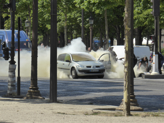 프랑스 파리 샹젤리제 거리에서 경찰차에 돌진해 폭발한 차량이 연기에 휩싸여 있다. /파리=AP연합뉴스
