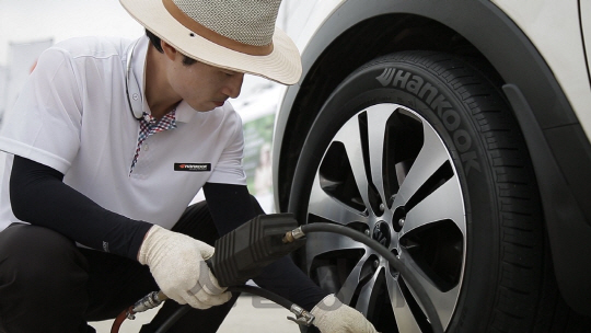 한국타이어 엔지니어가 한 고속도로 휴게소에서 고객의 차량 타이어를 점검하고 있다. /사진제공=한국타이어