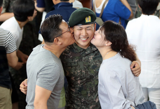 20일 충남 논산 육군훈련소 수료식에서 한 훈련병의 부모가 훈련병의 양볼에 입을 맞추고 있다.      /논산=연합뉴스