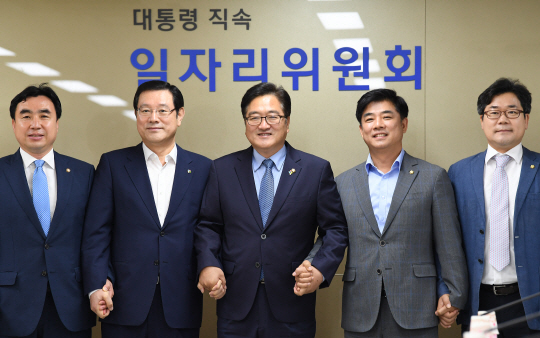 우원식(왼쪽 세 번째) 더불어민주당 우원식 원내대표를 비롯한 민주당 의원들과 이용섭(두 번째) 대통령 직속 일자리위원회 부위원장 등 관계자들이 21일 오전 서울 창성동 정부청사별관에서 열린 일자리 창출을 위한 간담회에서 손을 맞잡고 있다. /연합뉴스