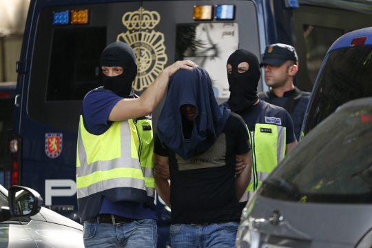 스페인 경찰이 21일(현지시간) 수도 마드리드에서 테러 모의혐의로 체포한 모로코 남성을 연행하고 있다. /마드리드=AP연합뉴스