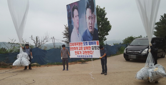 22일 오전 경기도 김포에 위치한 문수산에서 탈북민단체 자유북한운동연합 회원들이 북한에 장기간 억류됐다 혼수상태로 풀려난 뒤 사망한 미국인 대학생 오토 웜비어와 김정은을 규탄하는 내용의 대북전단을 살포하고 있다./연합뉴스