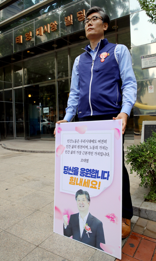 <YONHAP PHOTO-1472> 조대엽 후보자 사무실 앞 1인 지지 시위      (서울=연합뉴스) 권준우 기자 = 22일 오전 조대엽 고용노동부 장관 후보자의 청문회 준비 사무실이 마련된 서울 마포구 서울서부고용노동지청 앞에서 한 남성이 조 후보자를 지지하는 내용을 담은 피켓을 들고 1인 시위를 하고 있다. 2017.6.22      stop@yna.co.kr/2017-06-22 09:43:50/<저작권자 ⓒ 1980-2017 ㈜연합뉴스. 무단 전재 재배포 금지.>