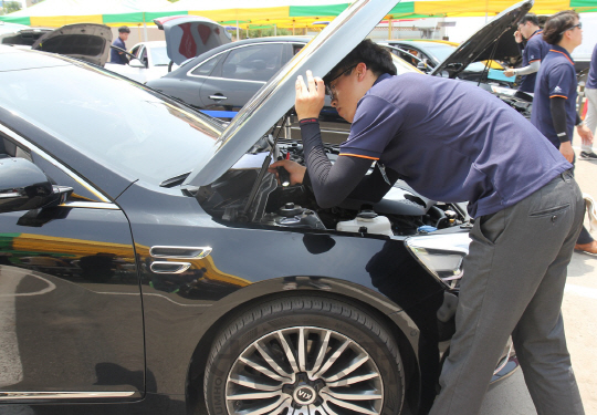SK엔카직영의 진단 경영 대회에서 한 참가자가 차량을 점검하고 있다. /사진제공=SK엔카직영