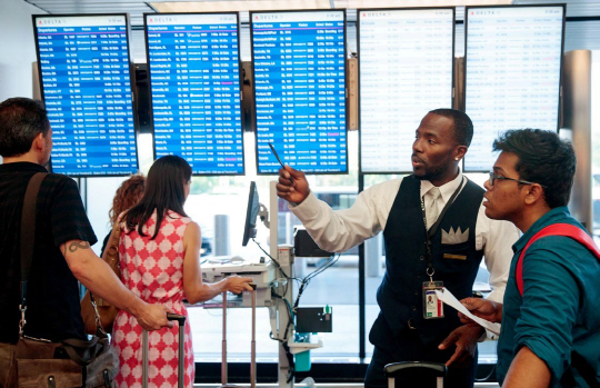 델타항공 직원들이 지난해 8월 뉴욕 라 가르디아 공항에서 승객들에게 시스템 마비로 전 세계 델타 항공기가 결항된 사실을 설명하고 있다.