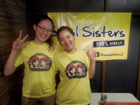안태양(왼쪽) 대표가 동생 찬양씨와 함께 서울시스터즈 로고 앞에서 활짝 웃고 있다.