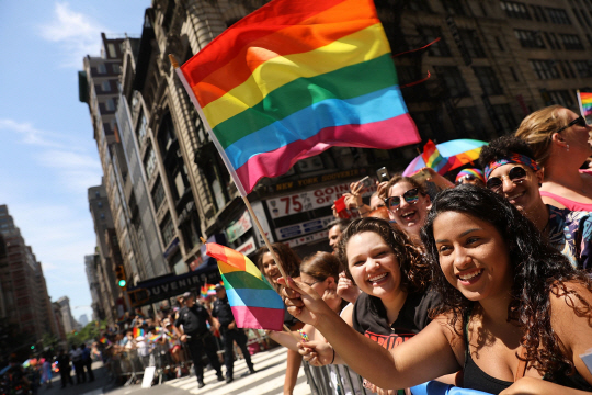25일(현지시간) 미국 뉴욕에서 진행된 게이 퍼레이드에서 한 여성이 동성애를 상징하는 무지갯빛 깃발을 흔들고 있다. /뉴욕=AFP연합뉴스
