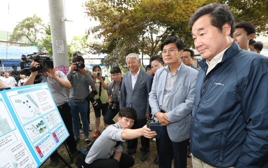 이낙연(오른쪽) 국무총리가 지난 24일 도시재생사업 현장인 평리문화마을을 방문해 관계자로부터 현황을 듣고 있다./연합뉴스