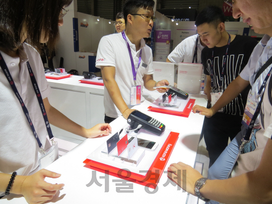 코나아이 직원들이 28일 중국 상하이에서 개막한 ‘2017 모바일월드콩그레스(MWC)’ 전시회에서 해외고객들을 상대로 자사의 전자결제 솔루션을 설명하고 있다. /사진제공=코나아이