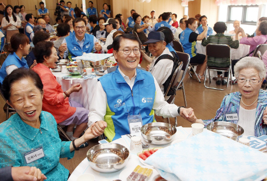 위성호(앞줄 가운데) 신한은행장이 30일 인천 삼산동 소재 부평구노인복지관에서 열린 ‘사랑의 비빔밥 데이’ 행사에서 어르신들과 함께 기념촬영을 하고 있다./사진제공=신한은행