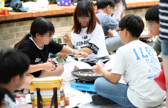 전국 학교 비정규직 노동자 파업으로 급식이 중단된 30일 서울시의 한 초등학교에서 학생들이 점심시간에 삼겹살을 구워 먹고 있다.  /연합뉴스