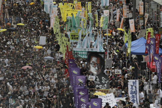 홍콩 반환 20주년을 맞이한 지난 1일 홍콩 도심에서 시민들이 반체제 인사이자 노벨평화상 수상자인 류샤오보의 사진을 앞세우고 “일국양제를 수호하자”는 구호를 외치며 시위를 벌이고 있다.   　 /홍콩=AP연합뉴스