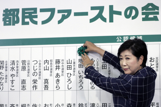 일본 도쿄도의회 선거가 치러진 2일 고이케 유리코 도쿄도지사가 자신이 이끄는 ‘도민퍼스트회’ 소속 후보의 당선이 확정되자 이를 축하하는 녹색 장미를 붙이고 있다. /도쿄=EPA연합뉴스