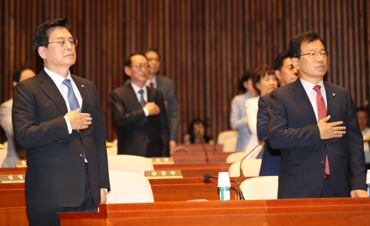 정우택(왼쪽) 자유한국당 원내대표가 4일 오후 국회에서 열린 의원총회에서 국기에 대한 경례를 하고 있다. /연합뉴스