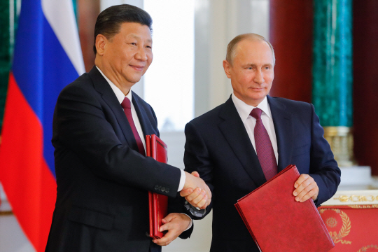4일(현지시간) 시진핑(왼쪽) 중국 국가주석과 블라디미르 푸틴 러시아 대통령이 러시아 모스크바 크렘린에서 악수를 나누고 있다. /모스크바=타스연합뉴스