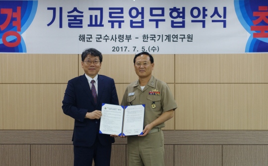 박천홍(왼쪽) 한국기계연구원장과 이병권 해군군수사령부 사령관이 업무 협약서에 서명한 뒤 들어보이고 있다./사진제공=한국기계연구원