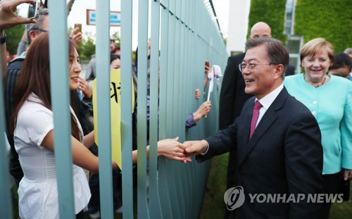 독일 베를린 총리실 앞을 찾아온 교민들과 손 잡는 문 대통령/연합뉴스